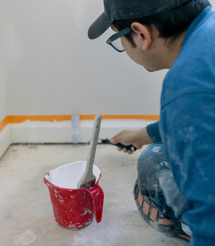 Man painting white trim and remodeling a home